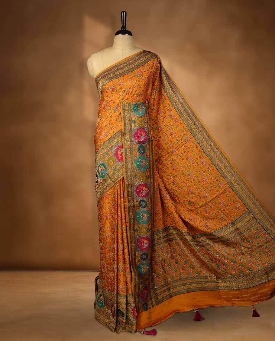 Orange colour Pashmina silk saree densely woven with intricate multicolour floral kodi pattern across the body, framed by an opulent arabesque border and grand storytelling pallu, paired with a matching woven border blouse piece