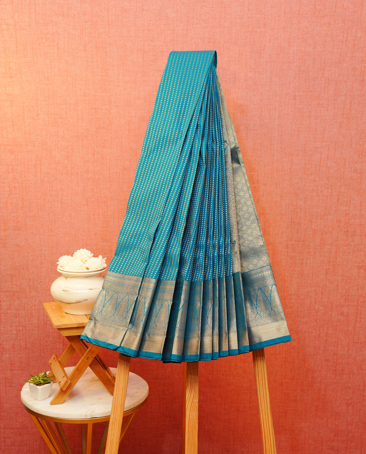 Peacock blue colour soft silk saree featuring gold zari buttas on body, contrast self colour gold zari traitionl border, grand pallu comes with matching blouse piece.