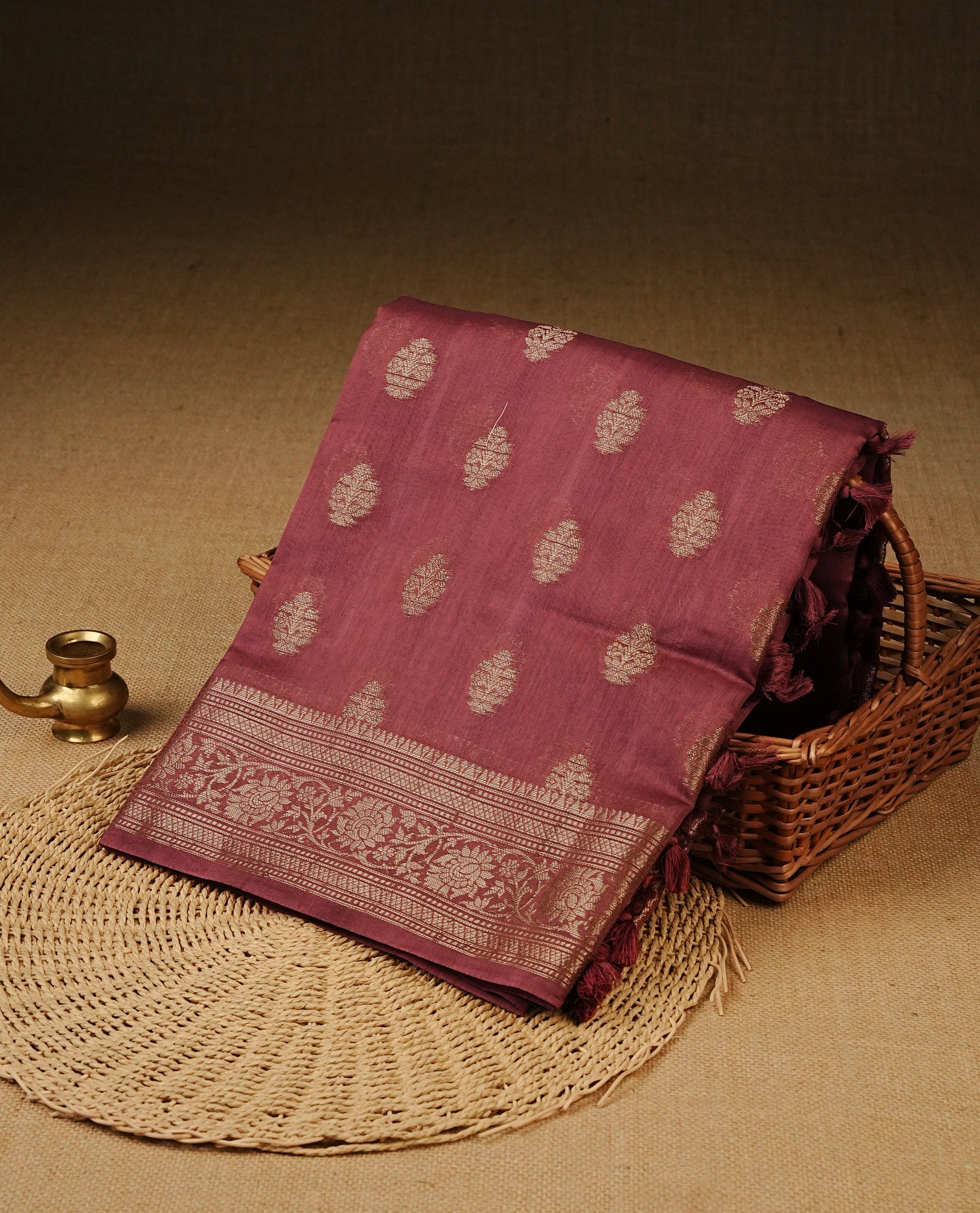 Pastel Onion Colour Tussar Silk saree with antique zari butta motifs On Body, a self-toned floral zari border, a rich zari pallu, and a matching blouse piece.