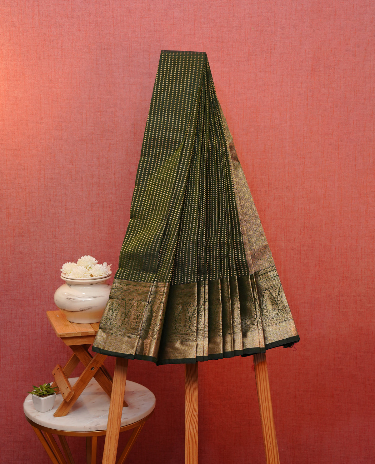 Dark green colour soft silk saree featuring gold zari buttas on body, contrast self colour gold zari traditonal border, grand pallu comes with matching blouse piece.