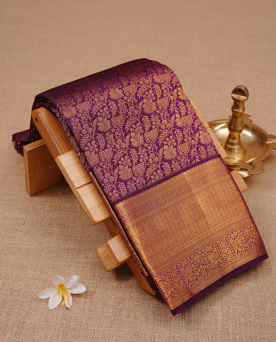 Purple colour kancheepuram silk saree featuring gold zari floral kodi pattern on body, complemented by self colour with traditional border, paired with matching blouse piece.
