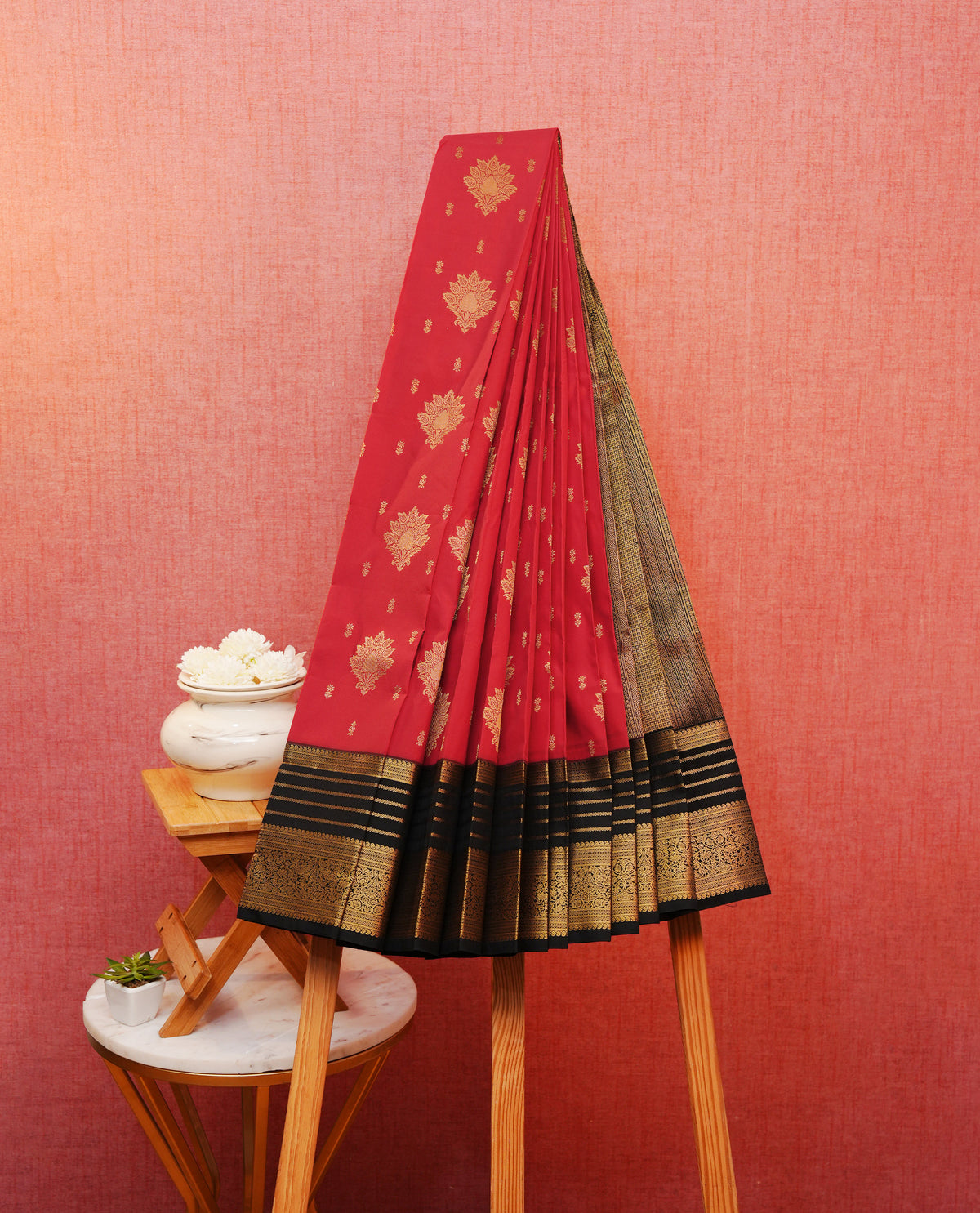 Red colour soft silk saree featuring gold zari motifs & buttas on body, contrast black colour traditional border, grand pallu comes with matching blouse piece.