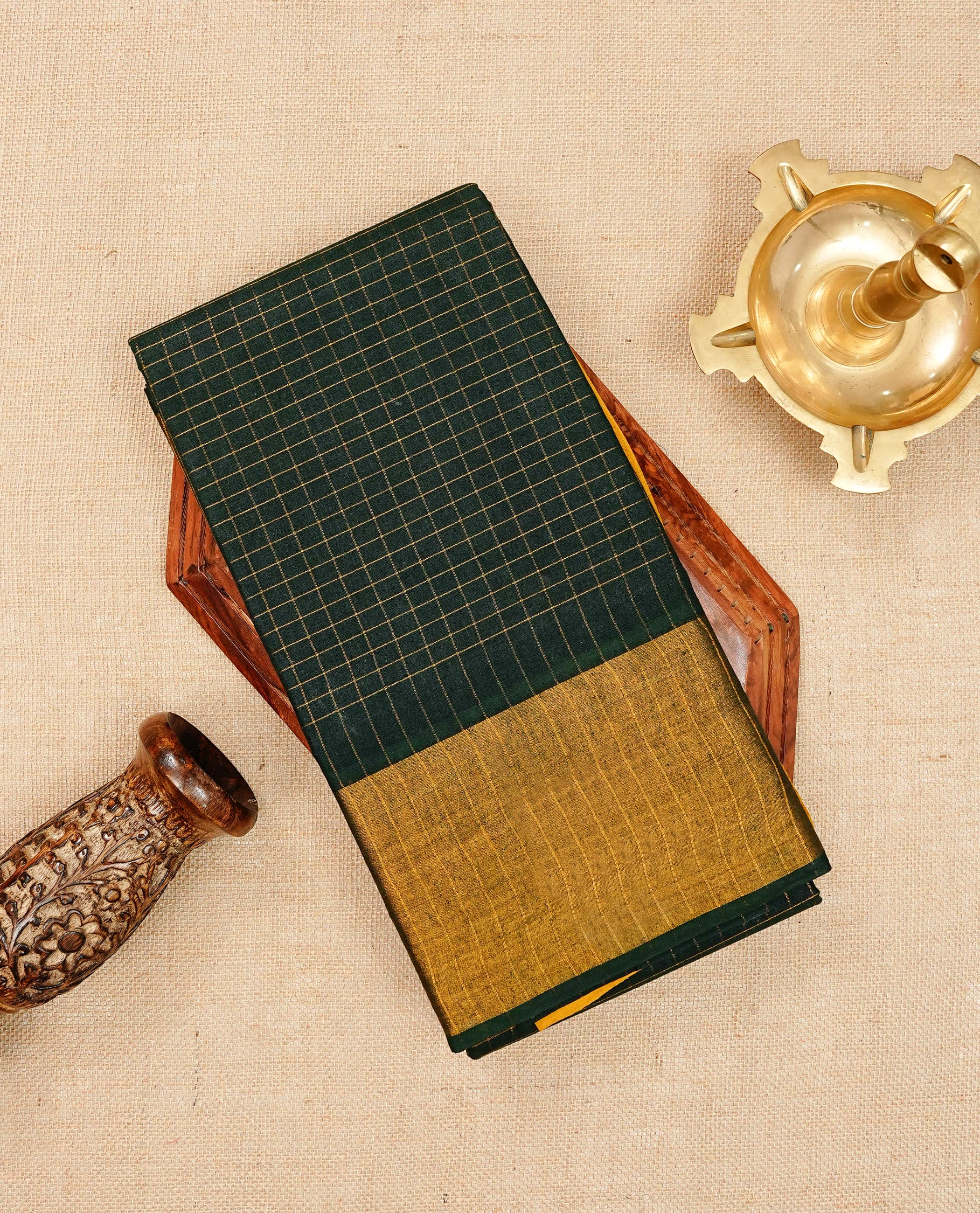 Dark green Sungudi cotton saree featuring elegant gold zari checks across the body, complemented by a contrast gold zari border. Comes with a matching blouse piece.