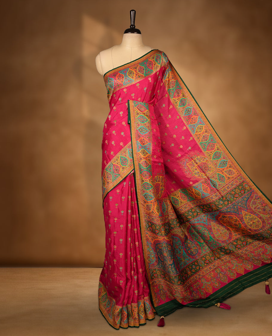 Rani Pink colour Pashmina silk saree densely woven with intricate multicolour floral motifs across the body, framed by an opulent arabesque border and grand storytelling pallu, paired with a matching woven border blouse piece