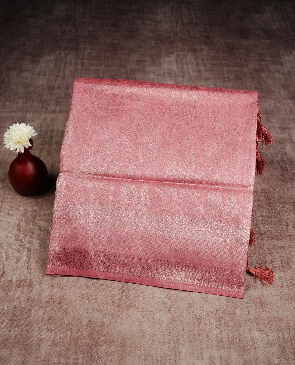 Pastel peach colour softie silk saree featuring silver zari, rich pallu floral brocade body, with contrasting self colour border.paired with matching blouse piece.