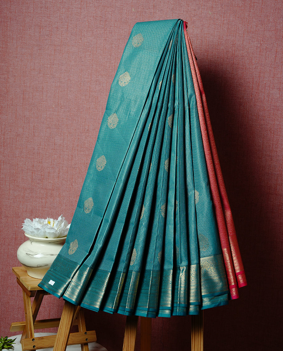Green coloured soft silk saree featuring gold zari stripes and motifs across the body, enhanced with a Self colour border and pallu, paired with a matching contrast blouse piece.