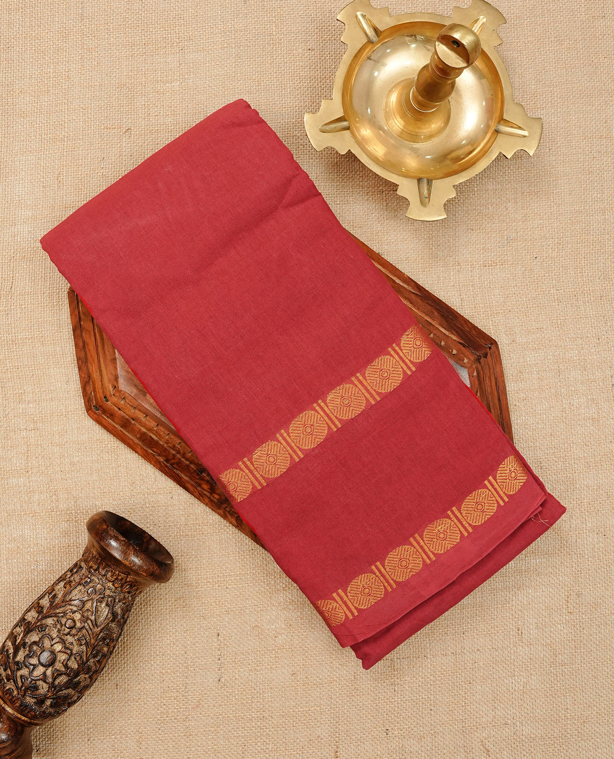 Red Colour Sungudi Cotton Saree with gold zari motifs on the body, a matching gold zari border, and a plain pallu. Paired with a contrast Dark Green colour blouse piece featuring a gold zari peacock border.
