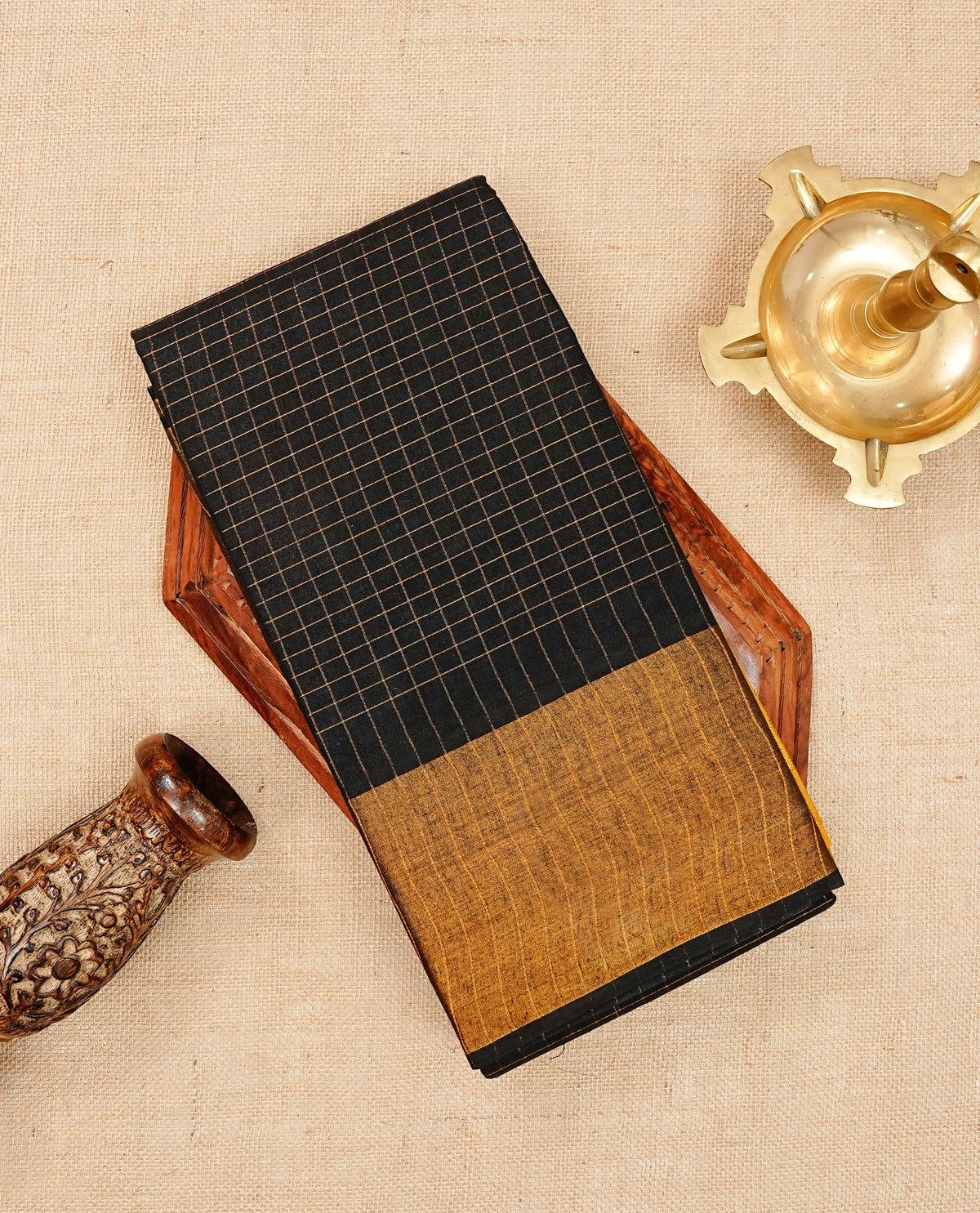 Black Sungudi cotton saree featuring elegant gold zari checks across the body, complemented by a contrast gold zari border. Comes with a matching blouse piece.