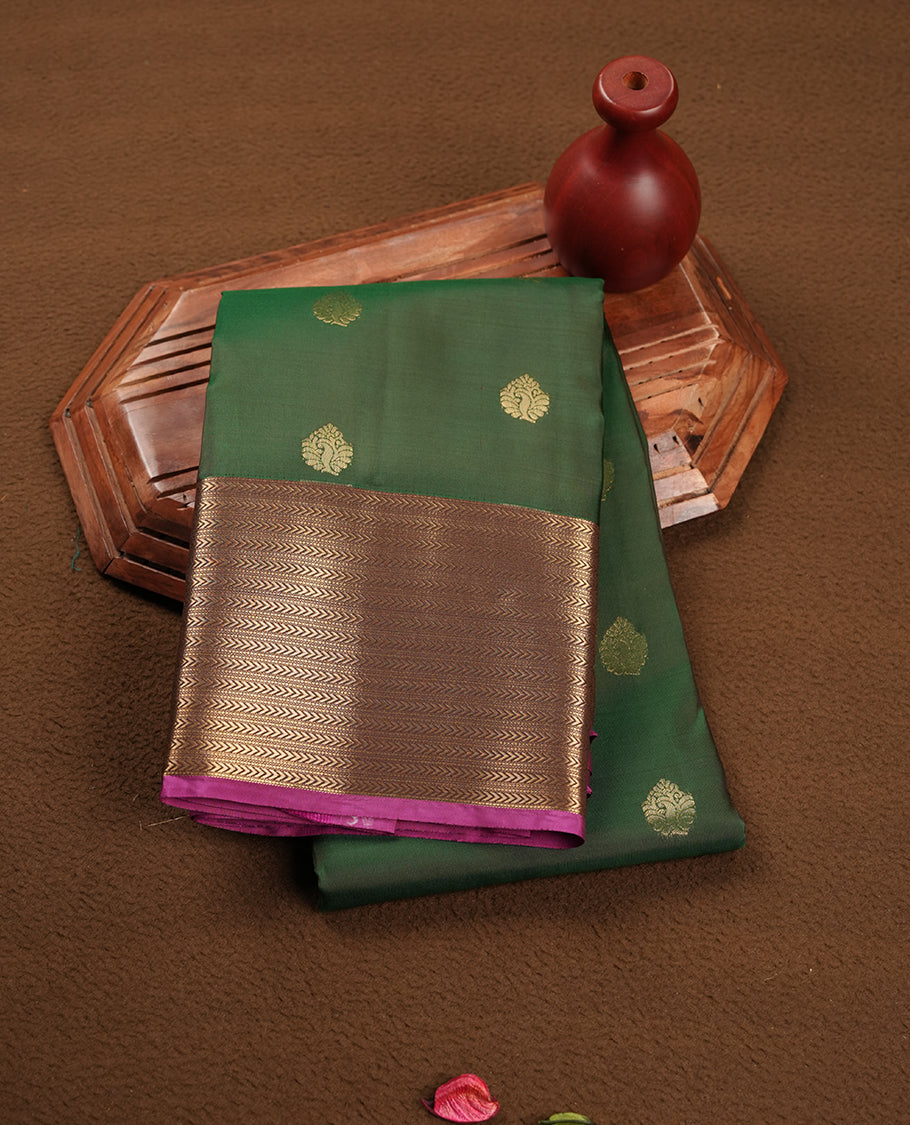 Green colour soft silk saree featuring gold zari motifs on the body, complemented by a contrast Magenta traditional zari floral kodi border and pallu, paired with a matching blouse piece.