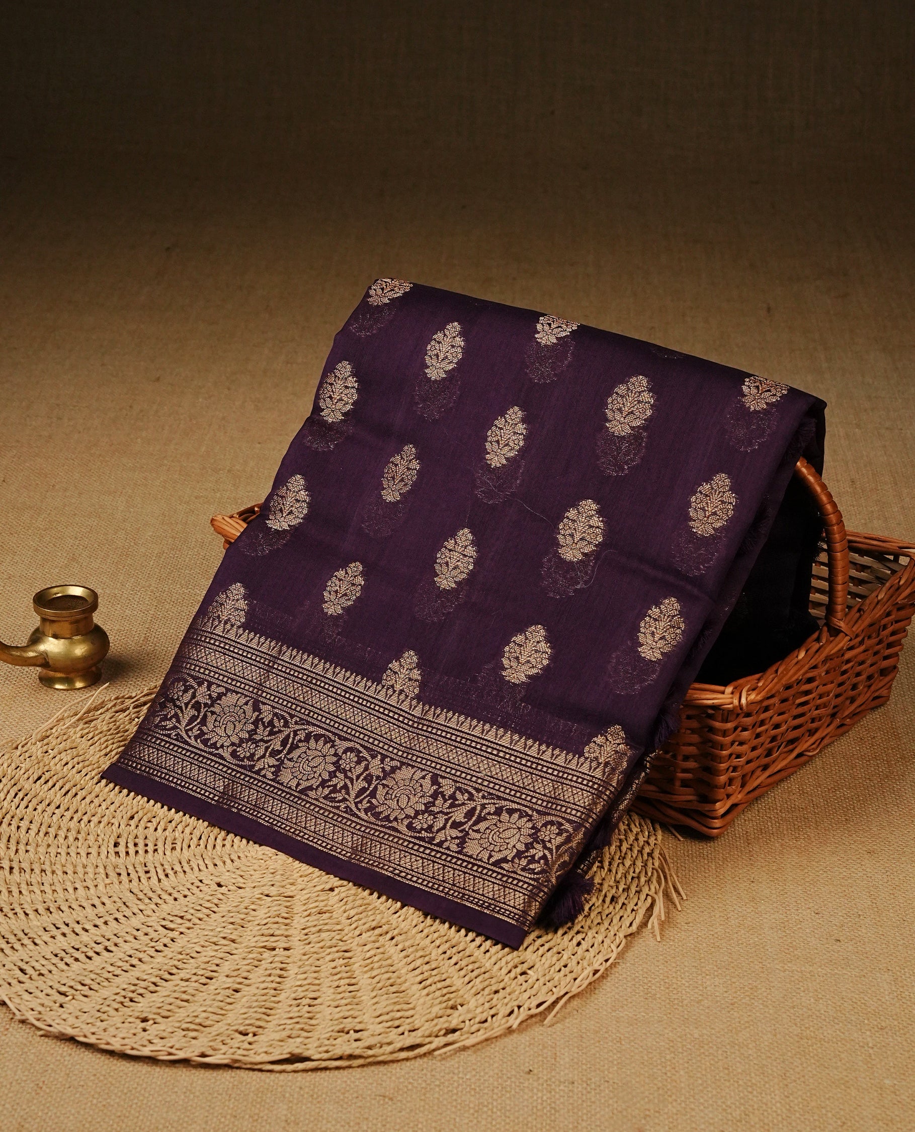 Royal Purple colour Tussar Silk saree featuring antique zari butta motifs on the body, enhanced with a self-coloured floral zari border and pallu, paired with a matching blouse piece.