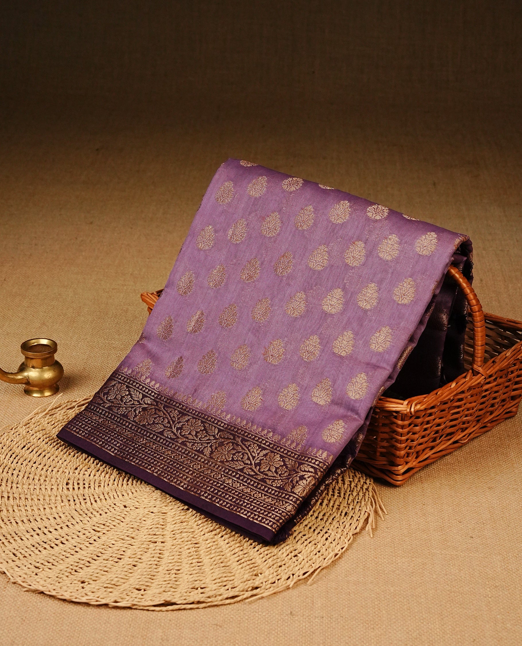 Light Purple Colour Tussar Silk saree adorned with antique zari butta motifs across the body, complemented by a contrasting Purple floral zari border and pallu, paired with a matching blouse piece.