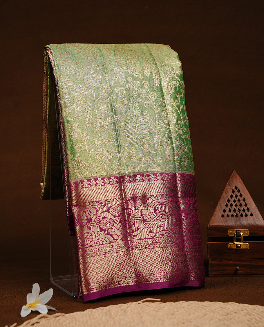 Green & gold double shade colour semi tissue silk saree featuring gold zari floral kodi pattern on body, contrast magenta colour with gold zari traditional border, paired with matching blouse piece.