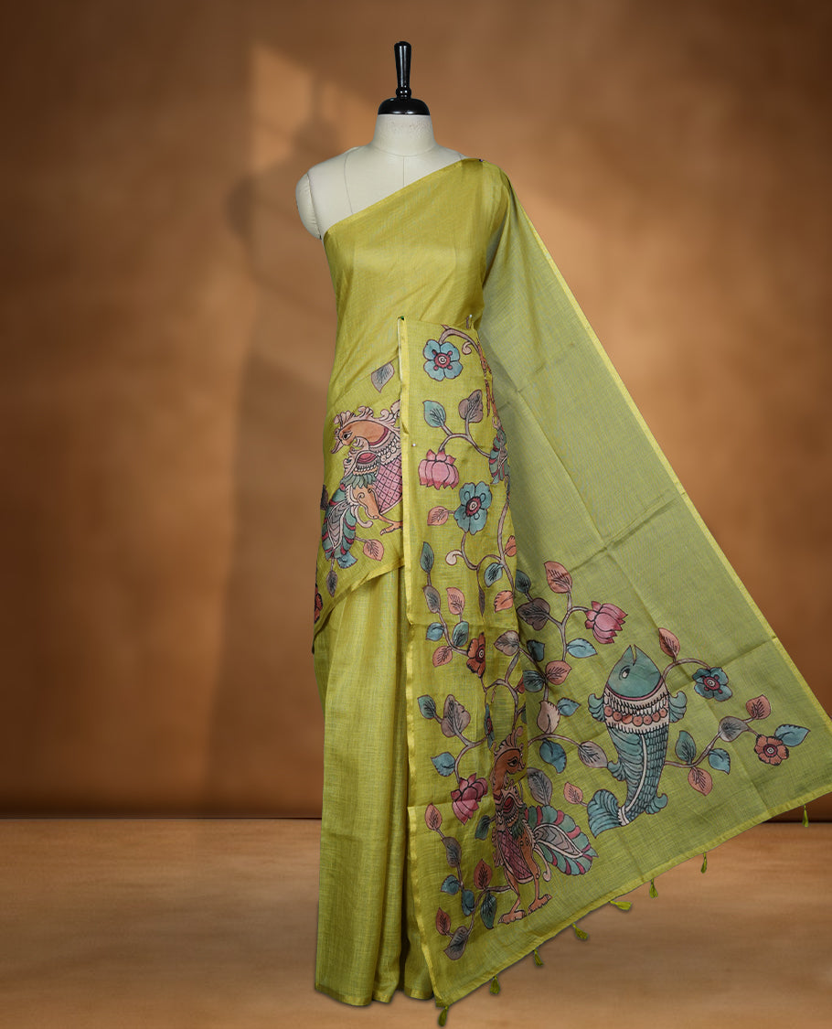 Lime green semi linen saree featuring hand painted floral and bird motifs across the pallu and border finished with subtle tassel detailing and paired with a matching floral print blouse