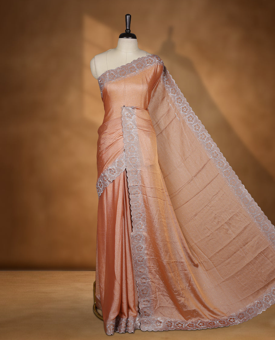 Peach colour shimmer designer saree, featuring a stone motifs on body, with heavy stone patttern on border and pallu, Paired with matching blouse.
