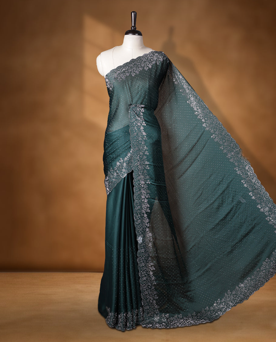 Dark green colour shimmer designer saree, featuring white scattered stone on body, stone work and heavy stone floral pattern on border and pallu, Paired with matching blouse.