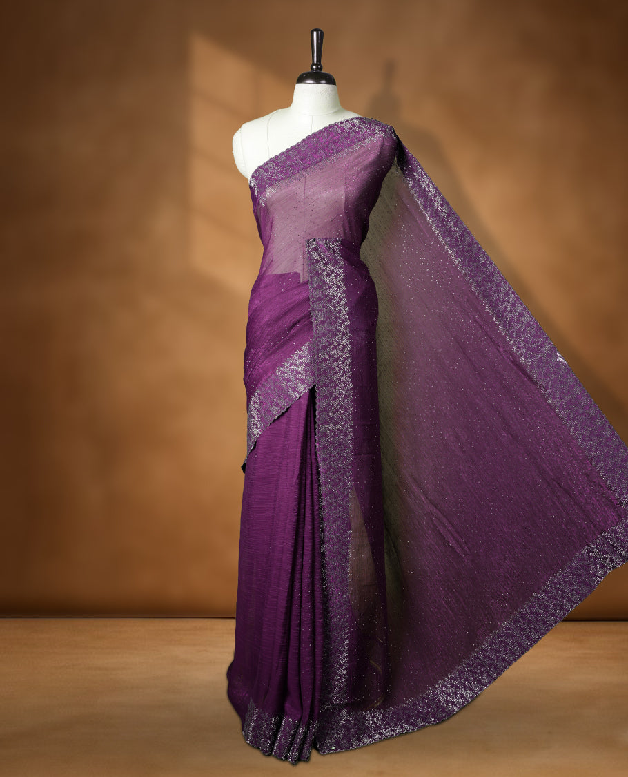 Dark purple colour chiffon designer saree, featuring white stone all over on body, heavy stone patttern on border and pallu, Paired with matching blouse.