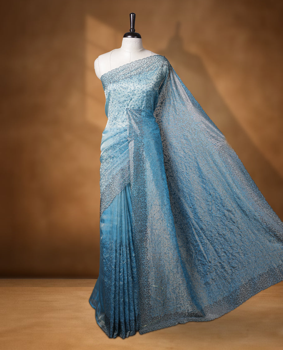 Light blue colour velvet chiffon designer saree, featuring self colour thread embroidery kodi work on body, stone work and all over motifs on border and pallu, Paired with matching blouse.