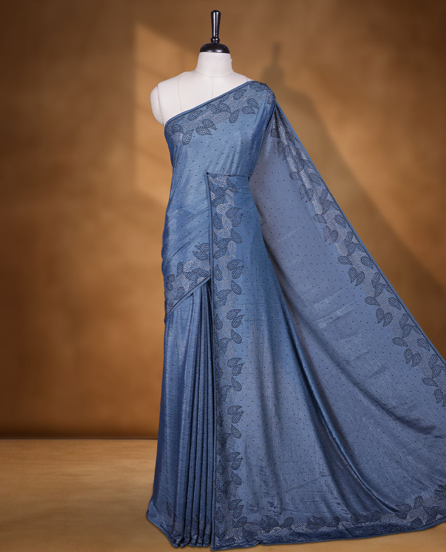 Ash blue colour chiffon designer saree, featuring black and white scattered stone on body, stone work and heavy stone leaf pattern on border and pallu, Paired with matching blouse.