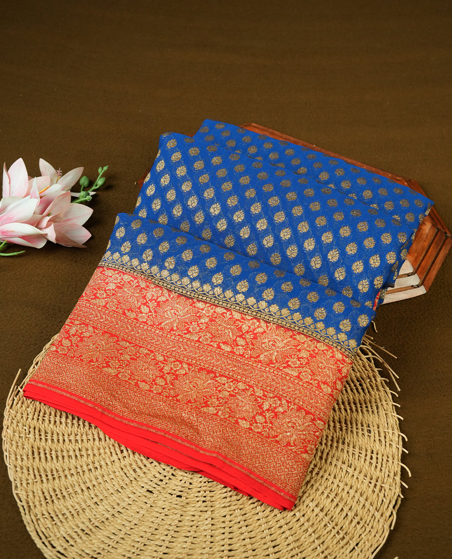 Dark Blue colour pure Banarasi Crepe saree featuring Antique zari Flower Motifs all over the body, complemented by an contrast Red dye colour with gold zari Floral Kodi Worked border and pallu, with matching blouse.
