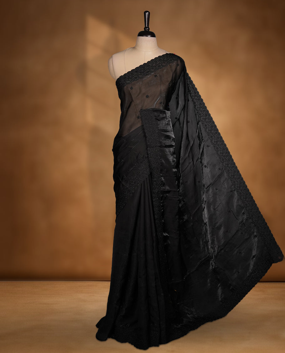Black colour organza saree featuring self colour thread embroidery work on body and border, paired with matching blouse piece.
