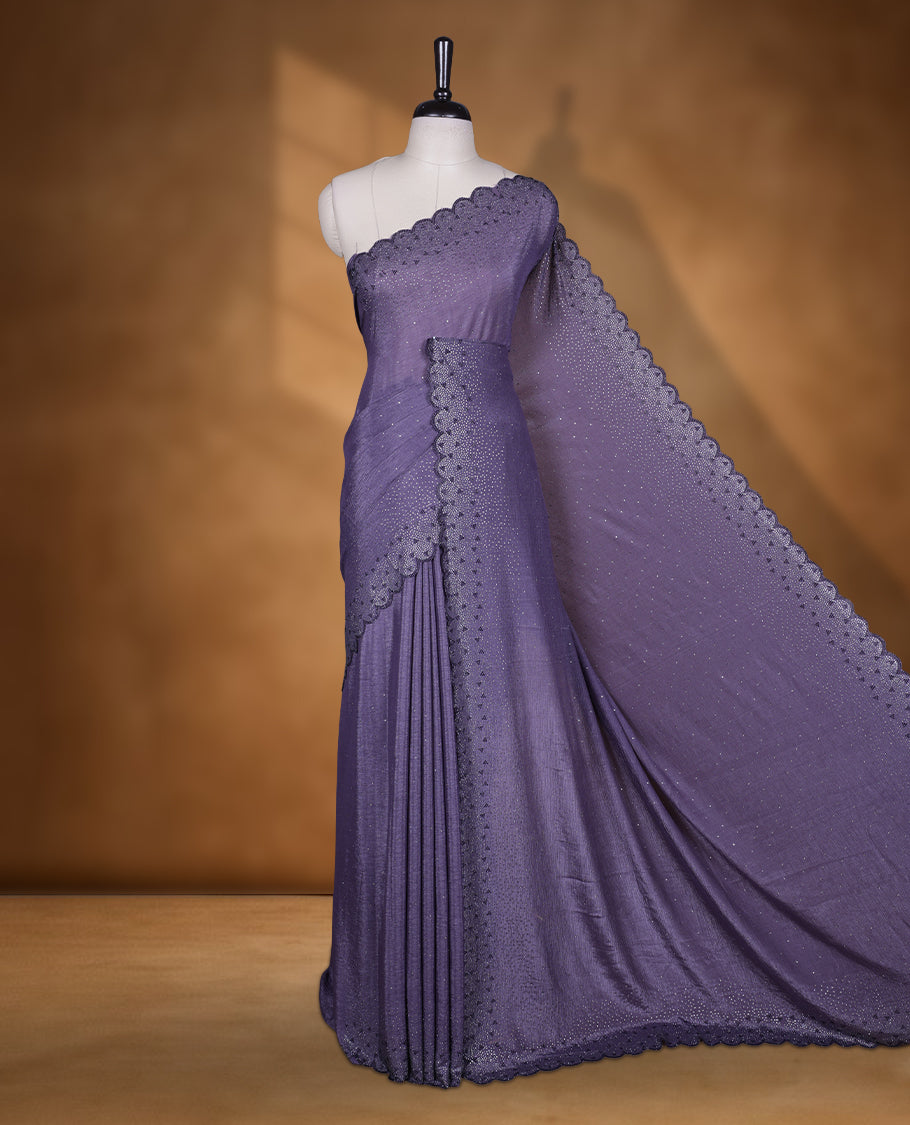 Dark pastel purple colour chiffon designer saree, featuring black and white scattered stone on body, stone work and heavy stone pattern on border and pallu, Paired with matching blouse.