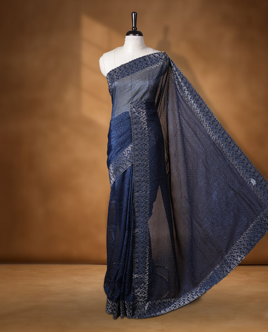 Dark blue colour chiffon designer saree, featuring white stone all over on body, heavy stone patttern on border and pallu, Paired with matching blouse.