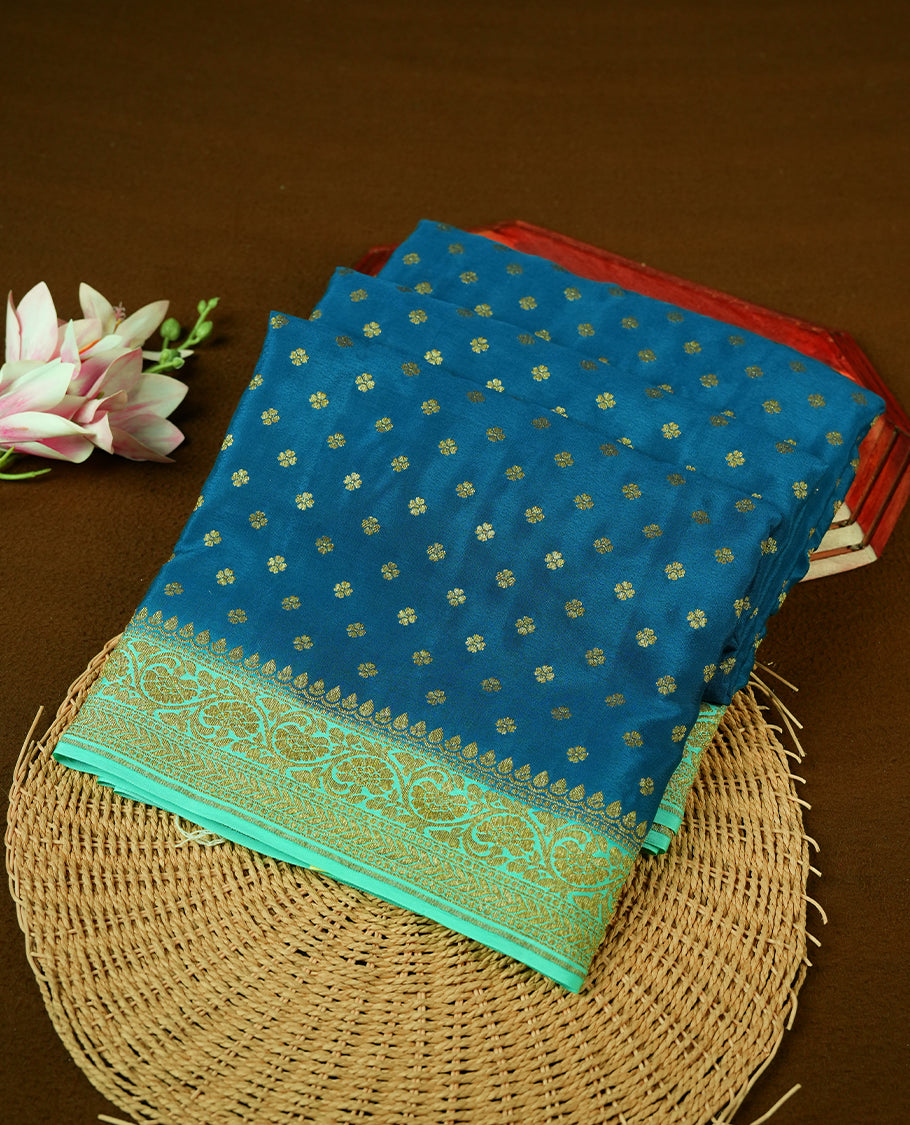 Dark Blue colour pure Banarasi georgette saree featuring gold zari Flower Motifs all over the body, complemented by an contrast sky blue dye colour with gold zari Floral Kodi Worked border and pallu, with matching blouse.