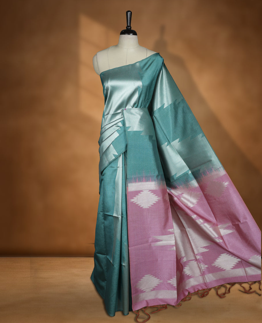 Green and silver dual tone colour semi tussar saree featuring woven abstract geometric motifs on the body, complemented by a ikat inspired patterned pallu, paired with a matching blouse.