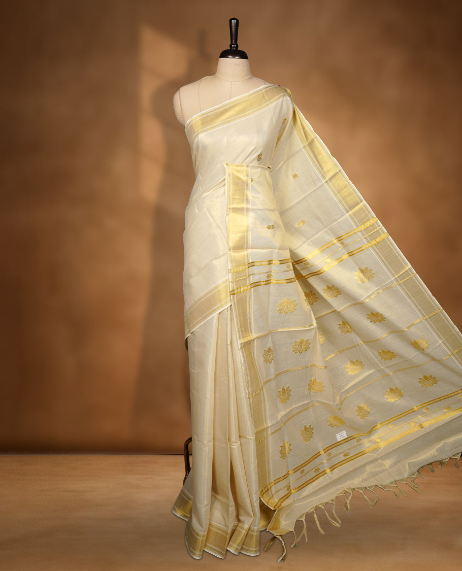 Elegant Light gold colour tissue Kerala saree with gold zari buttas, broad kasavu border, and richly woven traditional pallu, paired with a matching blouse
