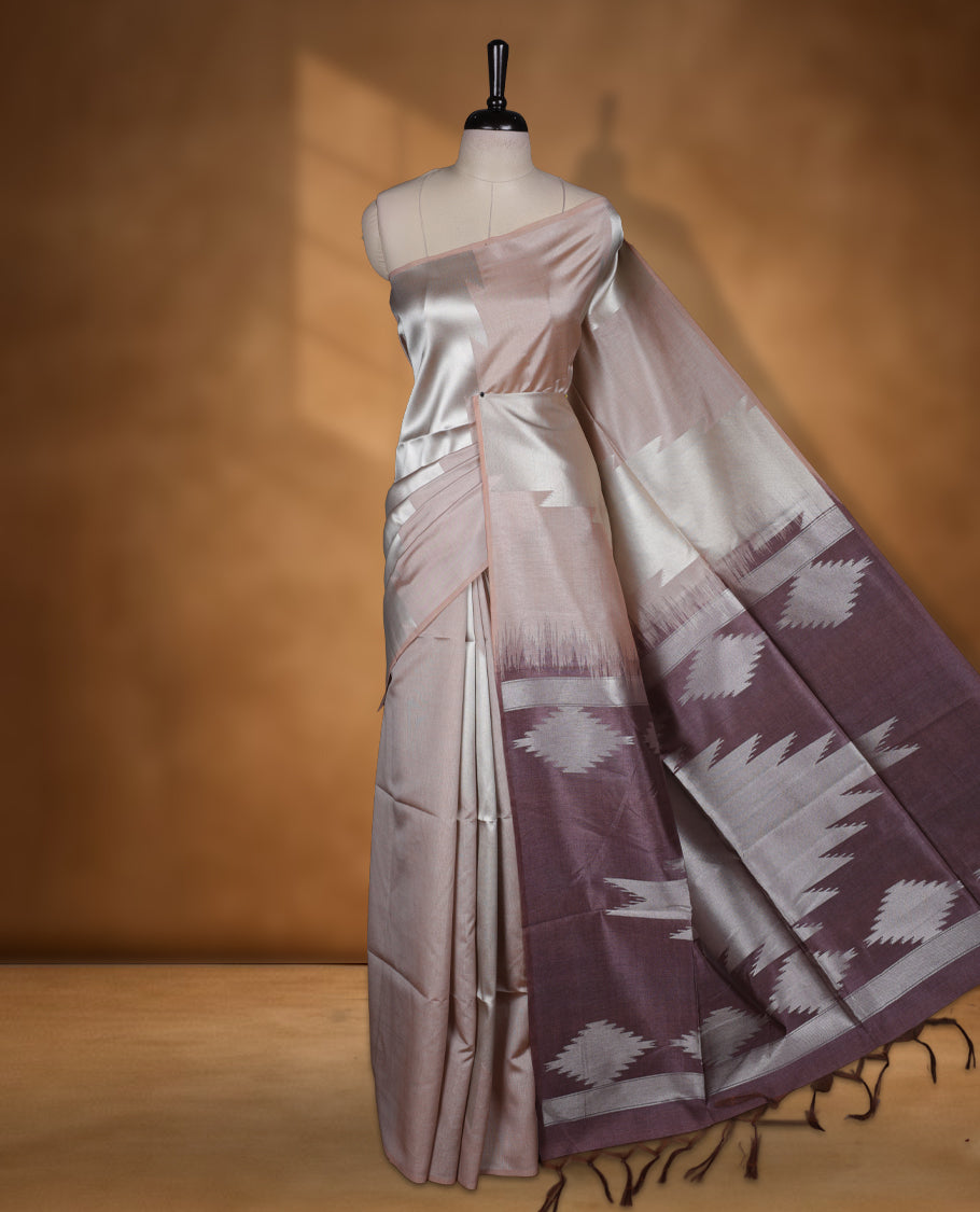 Cream and silver gold dual tone colour semi tussar saree featuring woven abstract geometric motifs on the body, complemented by a ikat inspired patterned brown pallu, paired with a matching blouse.