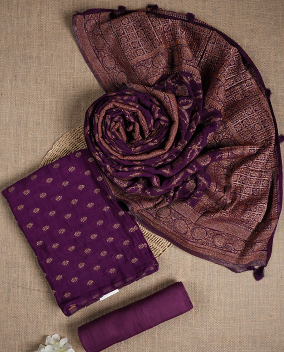 Grape colour suit material adorned with delicate golden motis & zari work & Comes with a beautifully woven dupatta and matching plain bottom fabric.