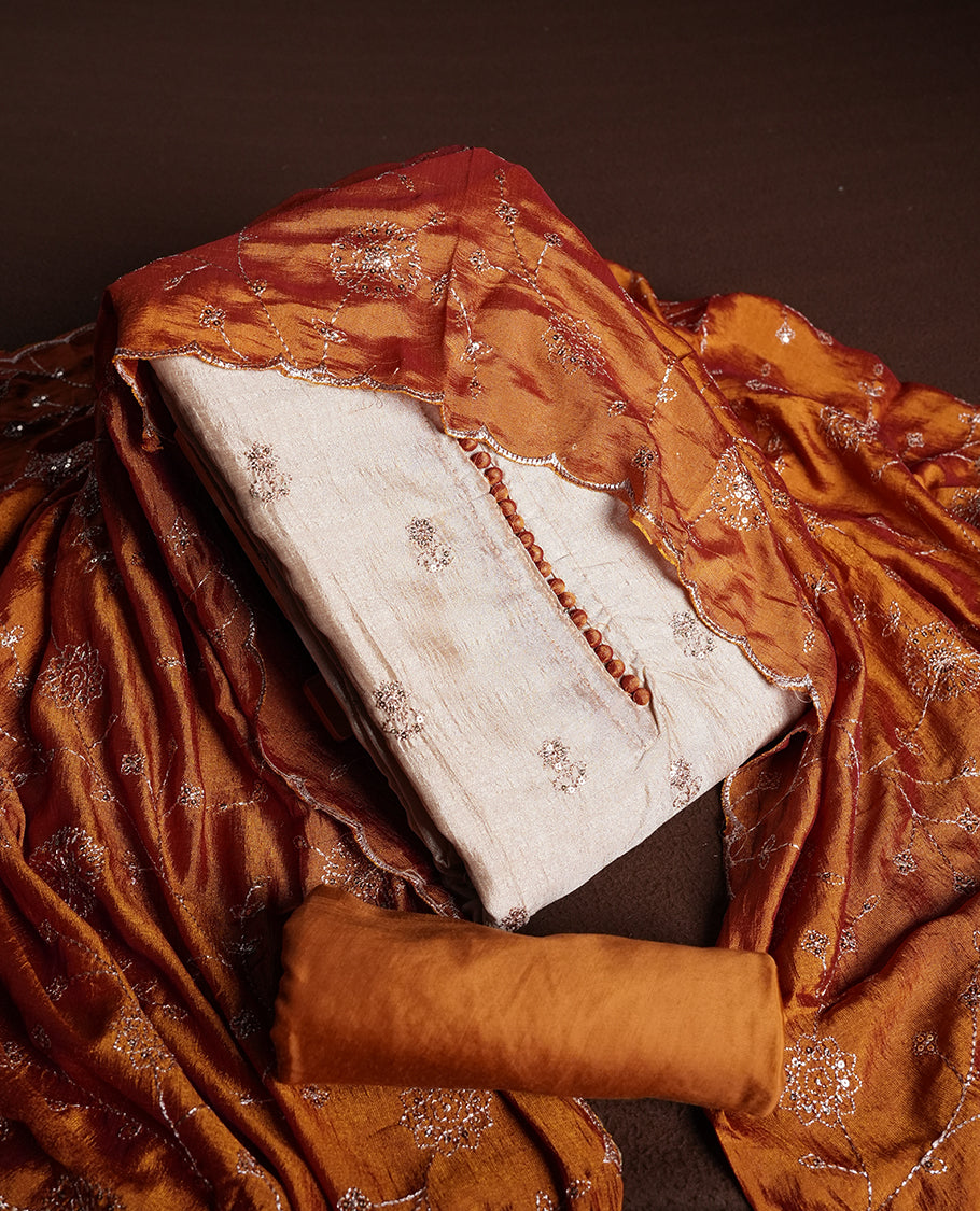 Golden Cream colour churidhar material featuring thread embroidery on the front panel, contrast orange colour dupatta with elegant border, and matching plain bottom