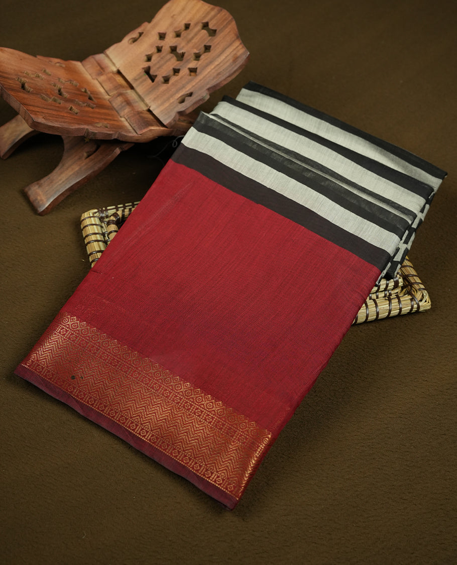 Maroon red colour mixed chanderi cotton saree with plain body, geometric tribal printed pallu with golden zari border, and striped blouse.