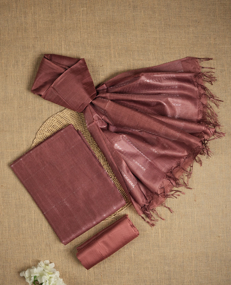 Pastel chocolate brown colour tussar suit material featuring a subtle self copper zari woven vertical and stripped pattern on the body, paired with a lightweight matching dupatta with tassel edges and a plain bottom piece.