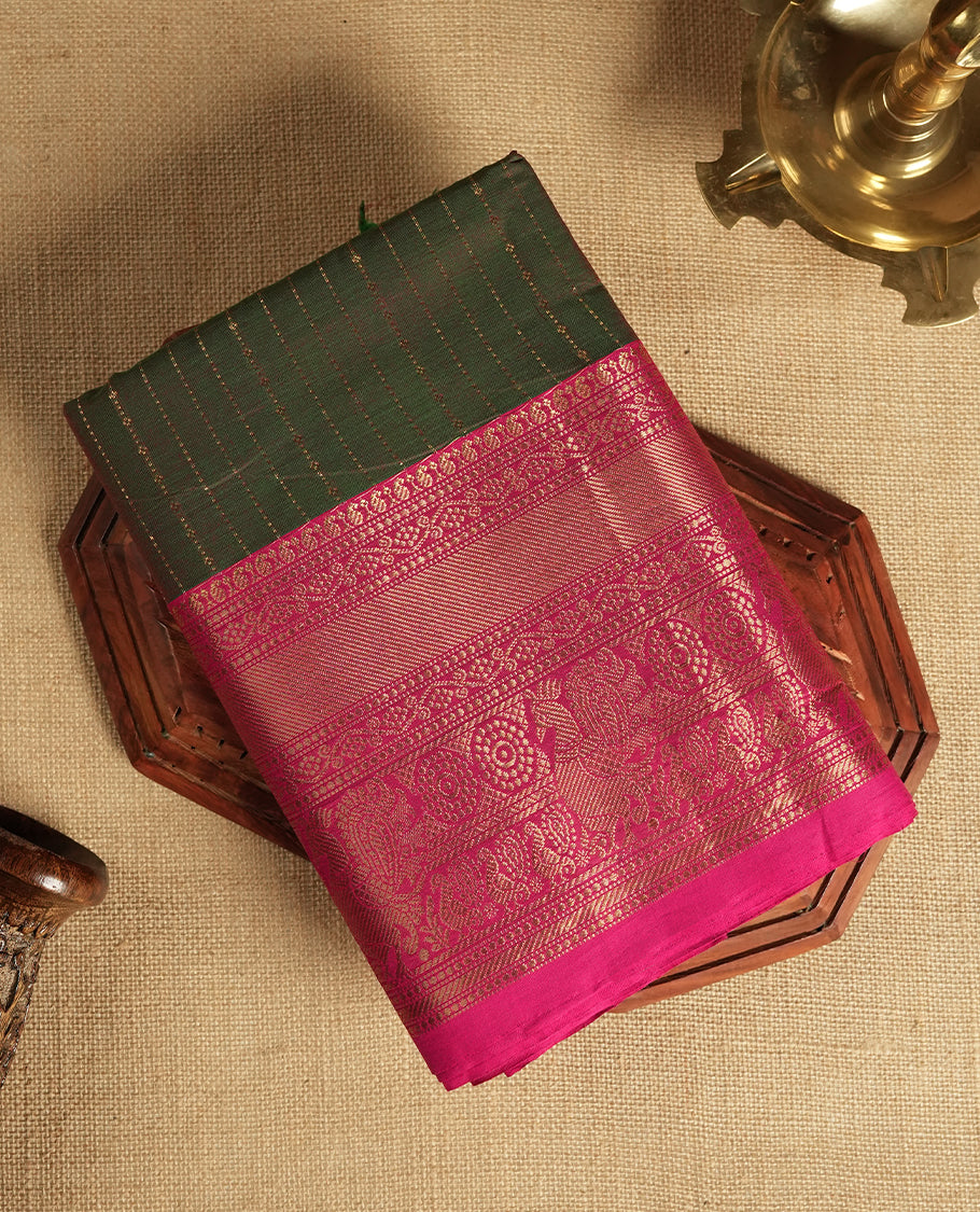 Green and magenta colour dual shaded Chettinad cotton saree adorned with delicate golden zari lines on the body, The rich magenta border features intricate floral and paisley zari motifs & Comes with a matching blouse piece.