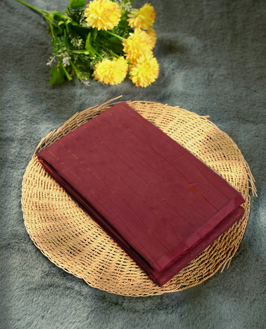 Dark onion colour silk cotton saree featuring with full of delicate vertical copper zari lines on the body & dark brown colour contrasted border, Crafted without a border for a classy touch, Comes with a matching blouse.