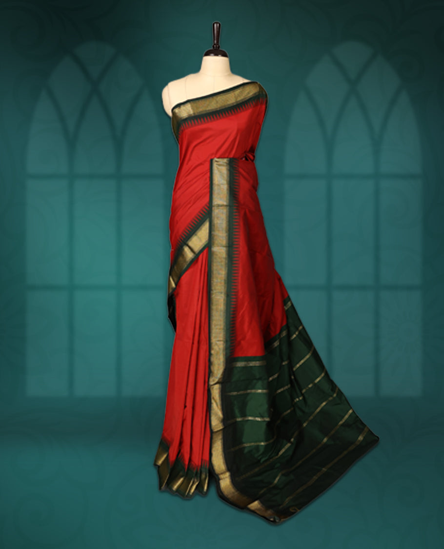 Vibrant Red semi silk saree with plain body, vibrant deep bottle green pallu and matching green border adorned with golden zari, accented with temple motifs along the edges, Paired with a matching blouse, perfect for festive occasions.