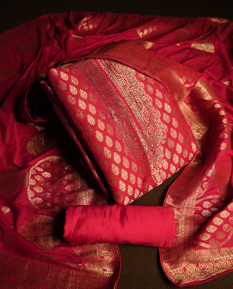 Maroon colour churidar material adorned with delicate golden stone work on the neckline, featuring zari leaf motifs across the body & Comes with a rich zari woven dupatta and a matching plain bottom.