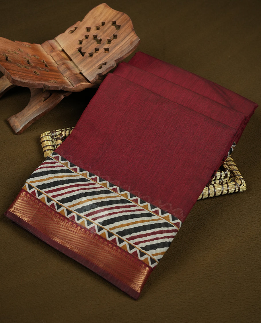 Maroon colour chanderi cotton saree with plain body, geometric tribal printed pallu with golden zari border, and diagonal striped blouse.