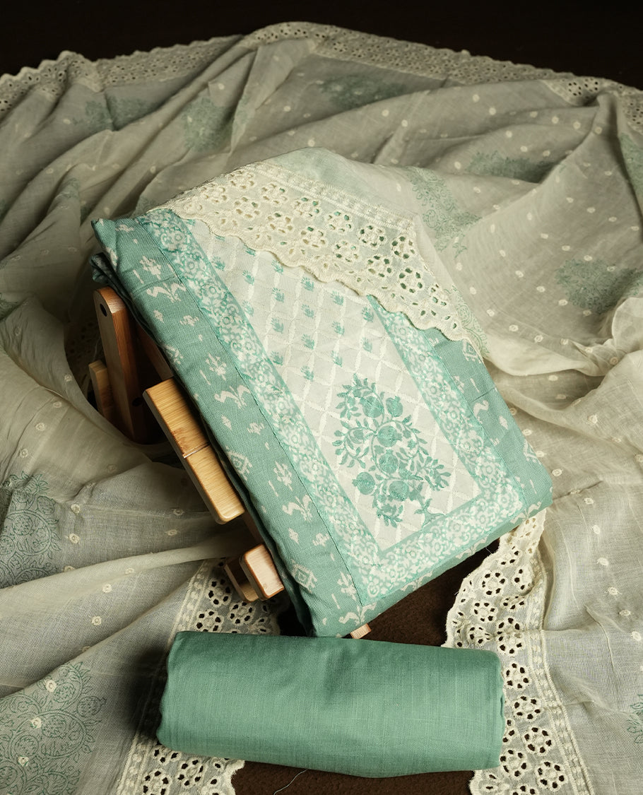 Pastel green and off white colour churidar material featuring elegant thread work on the neckline and floral motifs on the body, dupatta is adorned with delicate embroidered motifs and scalloped lace border & Comes with a matching bottom.