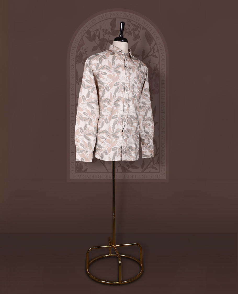 Cream colored shirt in soft cotton, featuring an all over leaf print in subtle earthy tones, Designed with a classic collar and roll up sleeves, it offers a perfect balance of tradition and ease.