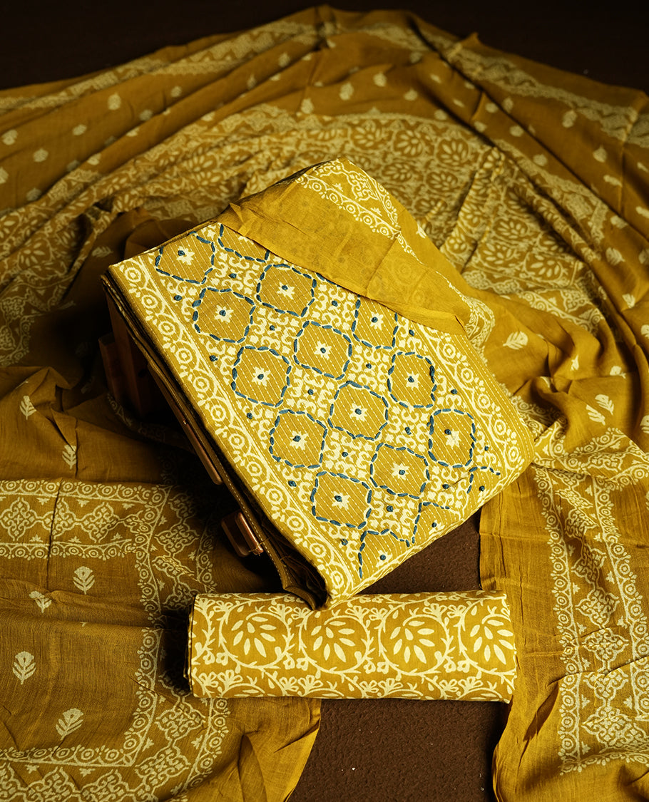 Dark golden yellow colour cotton churidar material featuring stripped body intricate white and blue thread work on block prints, complemented by a beautifully printed dupatta and matching printed bottom.