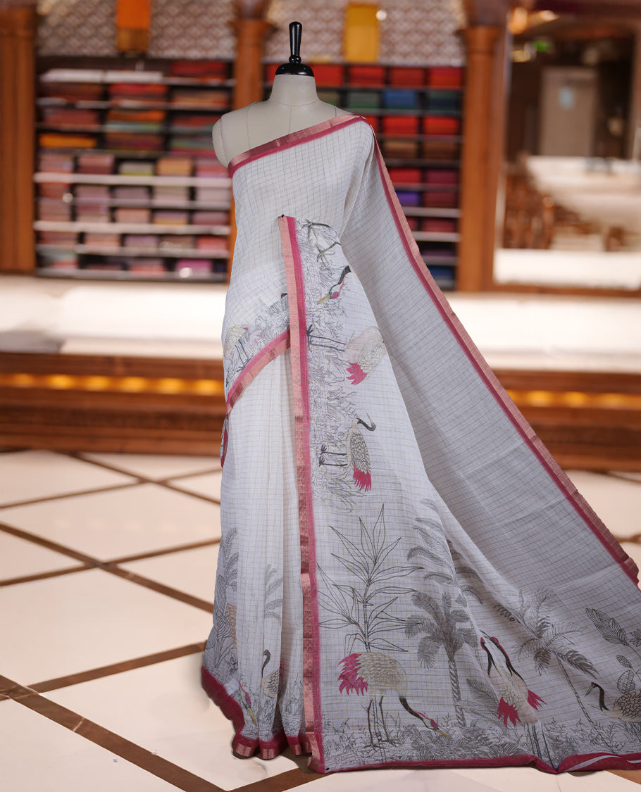 Off white colour Soft cotton saree featuring elegant bird prints along the edges, a stylish checked body, and a beautifully designed pink border & Paired with a matching blouse piece.