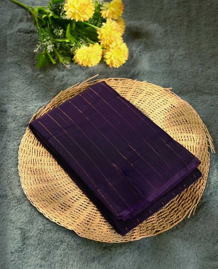 Dark violet colour silk cotton saree featuring with delicate vertical copper zari lines on the body, rich blue contrasted border & Crafted without a border for a classy touch, Comes with a matching blouse for a perfectly coordinated look.