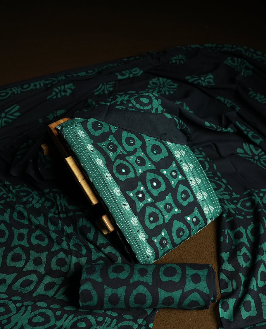 Peacock green and Navy blue colour cotton churidar material featuring embroidery striped body with mirror work on the neckline, highlighted with traditional tie dye patterns & Paired with a matching printed dupatta and printed bottom.