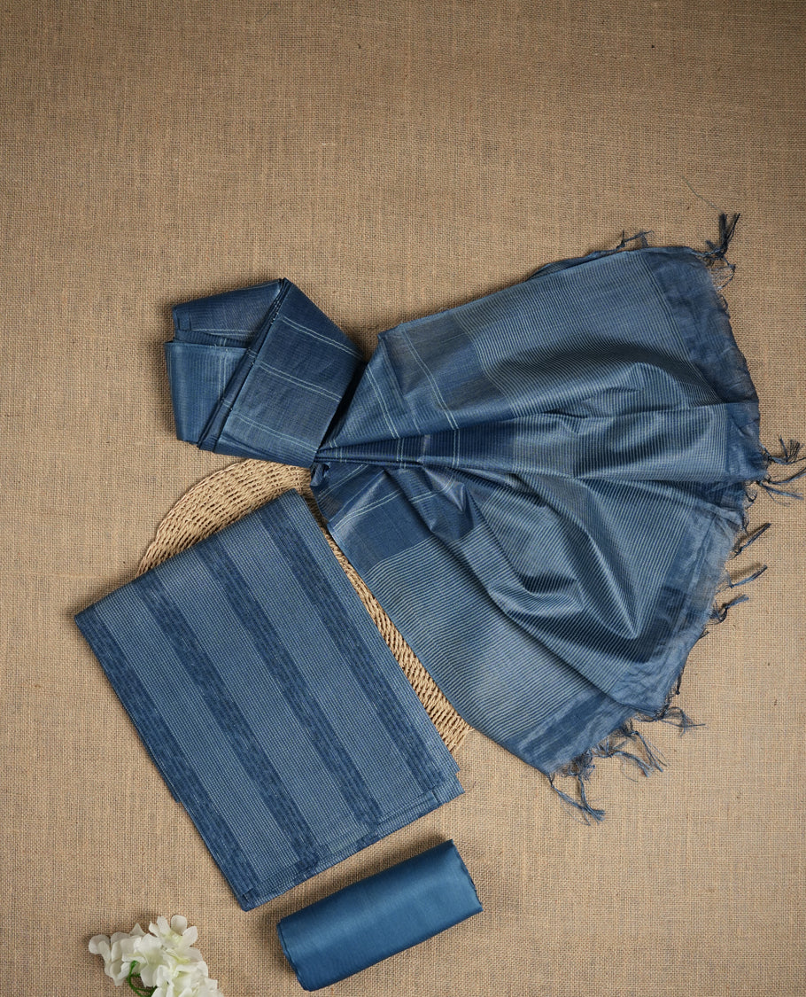 Denim blue colour tussar suit material featuring subtle striped patterns & Includes a soft dupatta with delicate tassels and matching plain fabric for the bottom.