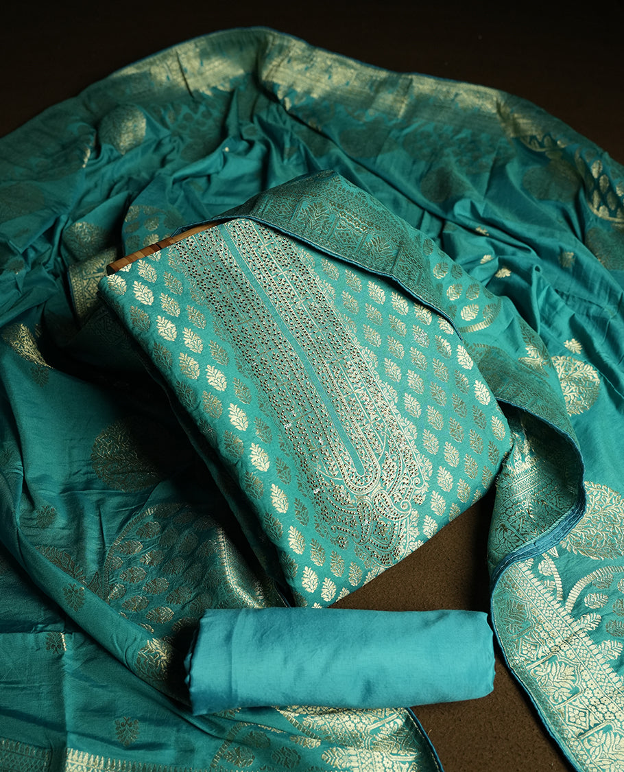 Turquoise blue colour churidar material featuring elegant golden stone work on the neckline, adorned with zari leaf motifs all over & Paired with a rich zari woven dupatta and a matching plain fabric for the bottom.