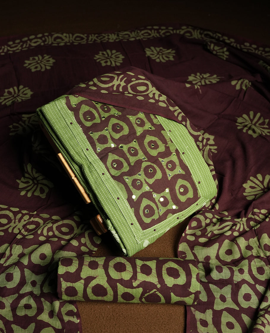 Green and Brown colour cotton churidar material adorned with mirror work on the neckline, featuring traditional tie dye patterns & Comes with a matching printed dupatta and coordinated printed bottom.