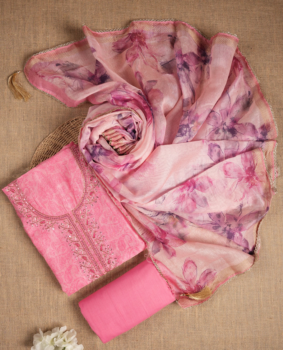 Pink colour suit material adorned with sequins and cut beads embroidery work on the neckline, exuding a graceful charm & Paired with a floral printed dupatta and a matching plain bottom.