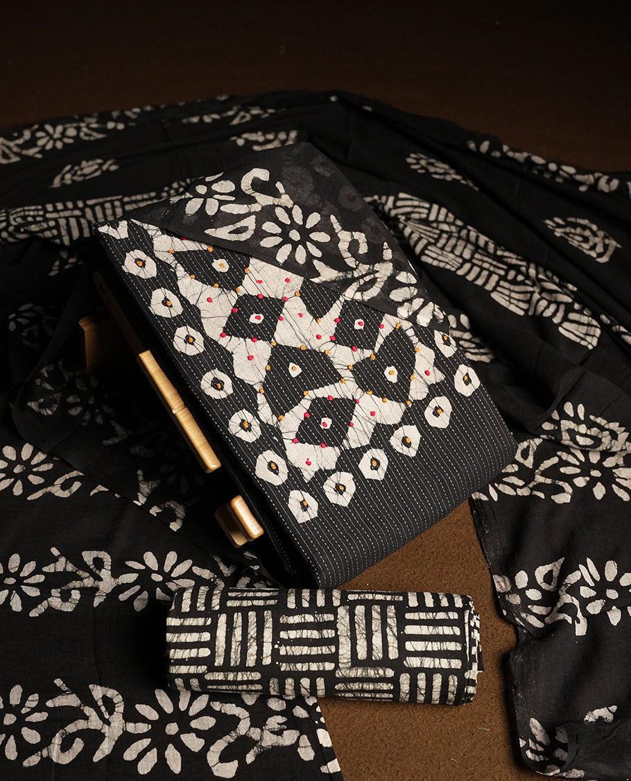 Black & Off white cotton churidar material adorned with thread work on the neckline, featuring traditional tie dye patterns and a stripped body & Comes with a matching printed dupatta and coordinated printed fabric for the bottom.